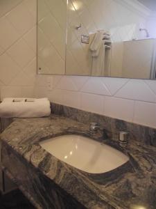 普雷图河畔圣若泽Augustus Plaza Hotel的一间带大理石水槽和镜子的浴室