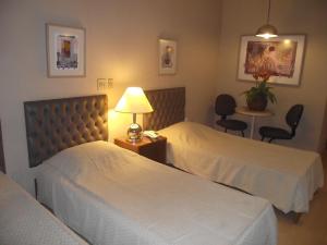 普雷图河畔圣若泽Augustus Plaza Hotel的酒店客房,设有两张床和一张桌子,椅子