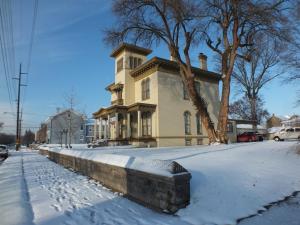 新奥尔巴尼The Pepin Mansion B&B on Mansion Row - 10 min to start of the Bourbon Trail的雪覆盖的街道上的黄色房子