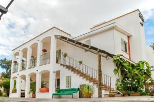 瓜达拉哈拉艾尔卡扎套房酒店的白色的房子,有楼梯和植物