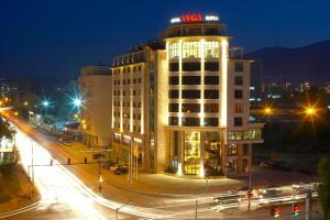 索非亚Hotel VEGA Sofia的一座在晚上上面有 ⁇ 虹灯标志的建筑