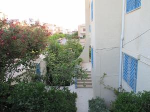 纳布勒Maison Karim的建筑旁边设有蓝色门和灌木的建筑