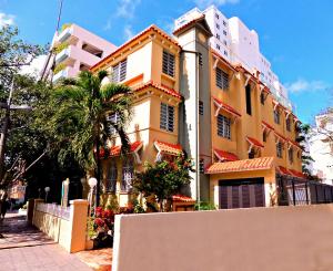 圣胡安卡纳里奥精品酒店的前面有栅栏的黄色建筑