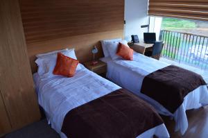 洛斯安赫莱斯Ruta Hotel Alto La Cruz的酒店客房设有两张床和一个阳台。