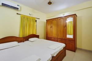 坎多林Saikunj Holiday Homes的一间卧室设有两张床和木制橱柜
