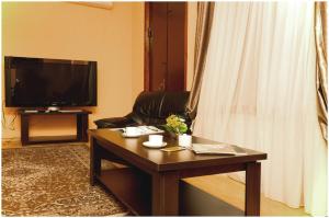 第比利斯大利达酒店的客厅配有咖啡桌和电视