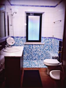 弗里米尼迪夸尔图Casa Vacanze Villa Flumini的一间带水槽和卫生间的浴室以及窗户。