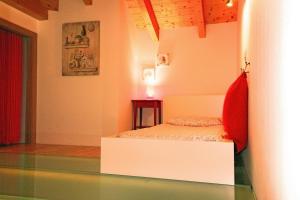 贝加莫Bombyx Inn的卧室配有白色的床和红色枕头