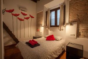 格拉纳达卡萨蒙塔尔班图瑞迪克公寓酒店的一间卧室配有一张带红色枕头的床