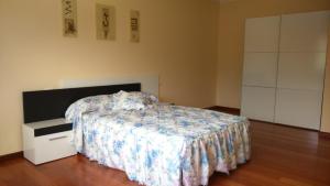 卡尔诺塔Apartamento Peralbar的一间卧室配有一张床、一个白色梳妆台和一张西德西德床