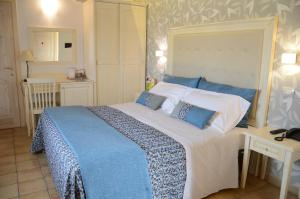 Puntarazzi阿日特米斯亚度假村的一间卧室配有一张带蓝白色床单的大床