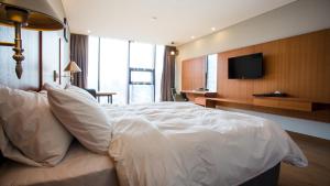 晋州市J广场婚庆酒店的一张大白色的床,位于酒店客房内