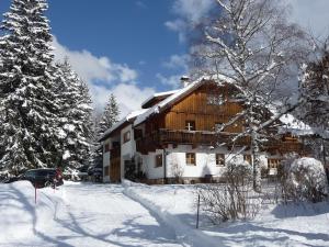 马尔尼茨Landhaus Fiausch的一座大木房子,在雪中,有树木
