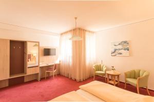 比特堡里安德酒店的酒店客房带一张床、一张桌子和椅子