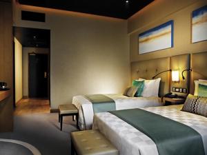 云顶高原Resorts World Genting - Highlands Hotel的酒店客房带两张床和长凳