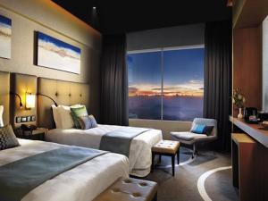 云顶高原Resorts World Genting - Highlands Hotel的酒店客房设有两张床和窗户。