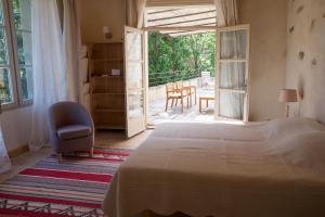瓦勒罗盖Le Clarou的一间卧室配有一张床和一把椅子,还有一个庭院
