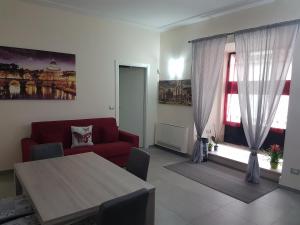 罗马毕&必公寓的客厅配有红色的沙发和桌子