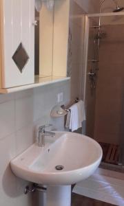 Lentate sul Seveso阿菲塔朱迪西旅馆的带淋浴的浴室内的白色水槽