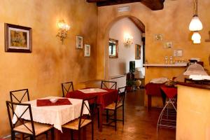 克雷马迪莫拉斯托里卡安蒂卡旅馆的一间用餐室,配有两张带红色桌布的桌子