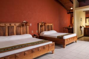 福尔图纳阿雷纳尔旅舍酒店的红色墙壁客房的两张床