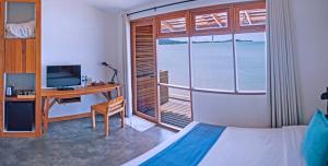 湄南海滩Escape Beach Resort - SHA Extra Plus Certified的一间卧室配有一张床、一张书桌和一个窗户。