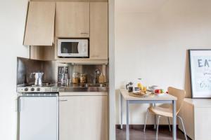 阿尔卡拉德荷那利斯希内尔德洛斯里奥斯大学公寓旅舍的一间带桌子和微波炉的小厨房