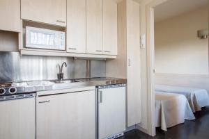 阿尔卡拉德荷那利斯希内尔德洛斯里奥斯大学公寓旅舍的厨房配有白色橱柜、水槽和桌子