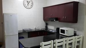 乌旺戈海滩Topanga Holiday Home的厨房配有带微波炉的柜台和时钟
