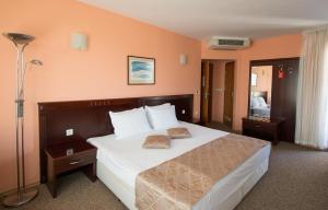 瓦尔纳Hotel Divesta - self check in的卧室配有一张带白色床单和枕头的大床。