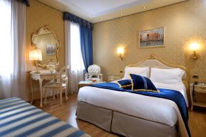 威尼斯Hotel Olimpia Venice, BW Signature Collection 3sup的酒店客房设有一张大床和一张书桌。