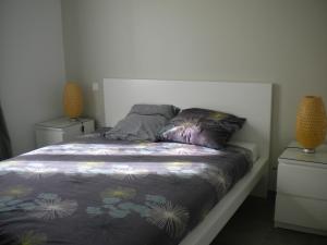 滨海苏拉克Nokanhui的卧室内的一张床位,配有2个床头柜和2盏灯