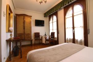 奥利特梅林达德奥利特酒店的一间卧室配有一张床和一张桌子及椅子
