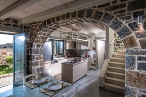 库基尼坎尼奥Anna Luxury Villa Cretevasion的厨房里的拱门,带有石墙