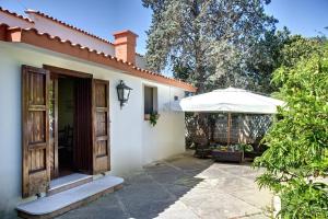 圣切萨廖迪莱切塞拉博尼斯度假屋的白色的房子,设有庭院和遮阳伞