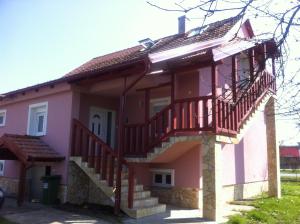 RatkovicaApartman Anka的粉红色的房子,设有楼梯和阳台