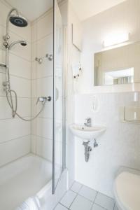 柏林帕卡诺酒店的带淋浴和盥洗盆的白色浴室