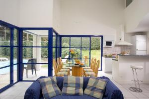 莫列马阿Madame Vacances Villas Club Royal Aquitaine的客厅配有蓝色的沙发和桌子