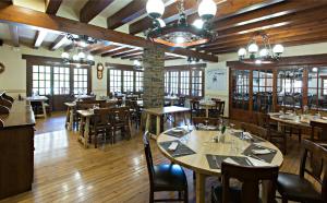 塞特卡萨斯拉科马酒店的餐厅铺有木地板,配有桌椅
