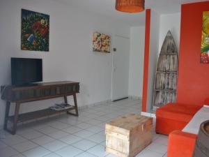 莱特鲁瓦西莱CoCoKreyol - " ARUBA"的客厅配有电视、桌子和沙发