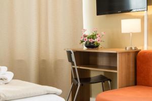 柏林帕卡诺酒店的酒店的客房,配有带鲜花的书桌