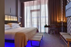 丰沙尔丰沙尔CR7佩斯塔纳酒店&度假村 的一间卧室配有一张床、一张书桌和一个窗户。