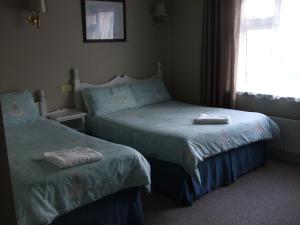 基拉尼汉墨尼酒店-格雷恩小屋的一间卧室设有两张床和窗户。