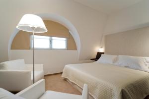 卢森堡爱斯尼酒店的卧室配有床、椅子和窗户。