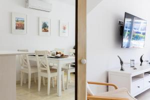 艾姆布里亚布拉瓦Vista Roses Mar - Casa Pescador的白色的用餐室配有白色的桌椅