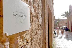 埃里切Residence San Martino的墙上的标志,人们沿着街道走