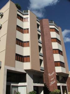 马卡埃水晶酒店的一座高大的白色建筑,设有棕色的窗户