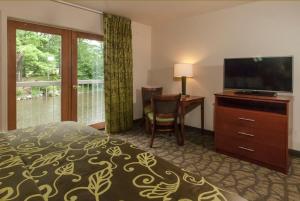 切罗基河滨汽车旅馆的一间卧室配有一张床、一台电视和一张书桌