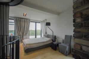 里加Riga Luxury Loft with Terrace的一间卧室设有一张床、一个窗口和一把椅子