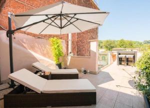 罗马加里波第屋顶花园公寓的庭院配有遮阳伞、椅子和桌子。